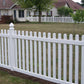 Weatherables Chelsea white vinyl picket fence in front of a residential house with green grass and trees.