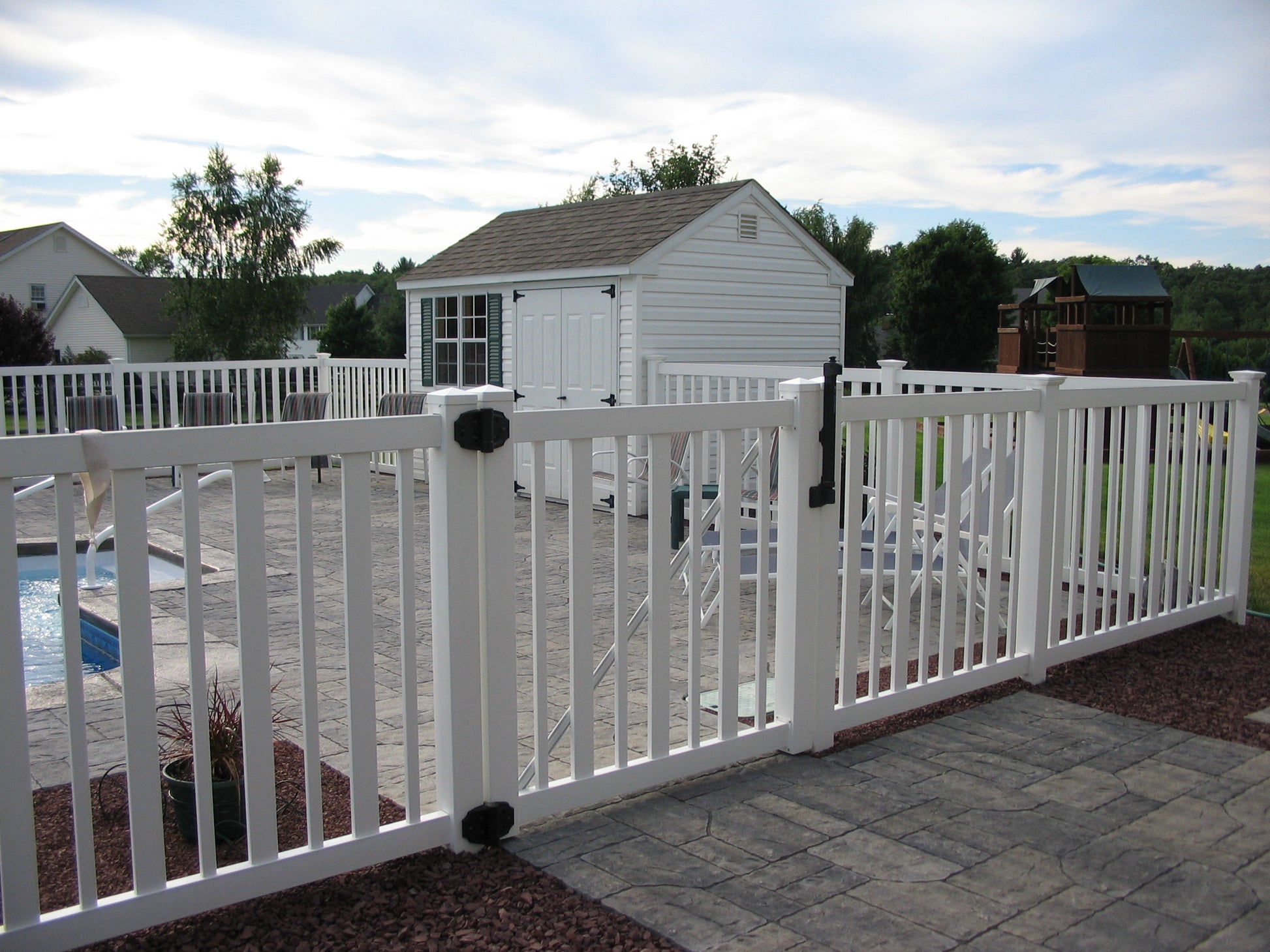 Weatherables Atlantis white vinyl pool fence with a pool and shed in the background