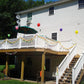 White house with a decorated Weatherables Washington white vinyl deck railing featuring colorful balloons and an umbrella.