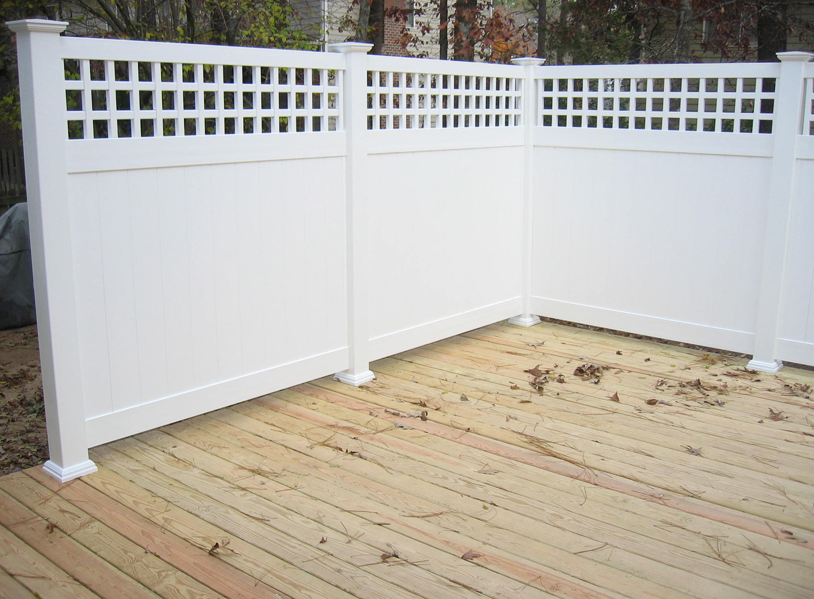 Weatherables Scottsdale white vinyl lattice privacy fence on a wooden deck