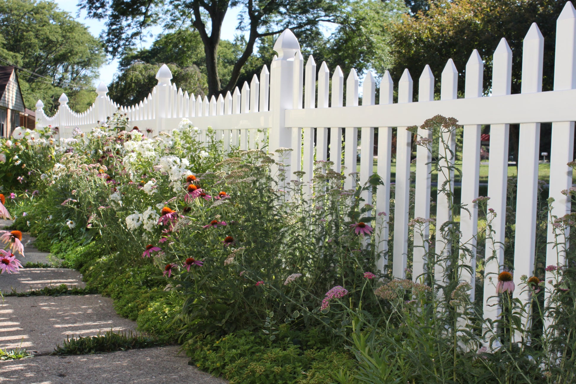 Garden with Weatherables Hampshire white vinyl picket fence and flowers