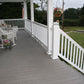 Front porch with Weatherables Washington white vinyl deck railing, chairs, and a small table with flowers on a grassy area.
