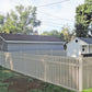 Backyard with a Weatherables Sarasota tan vinyl pool fence, grass, and trees under a clear sky.