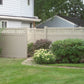 Neighborhood scene with a house, Weatherables Ashton khaki vinyl privacy fence, and greenery