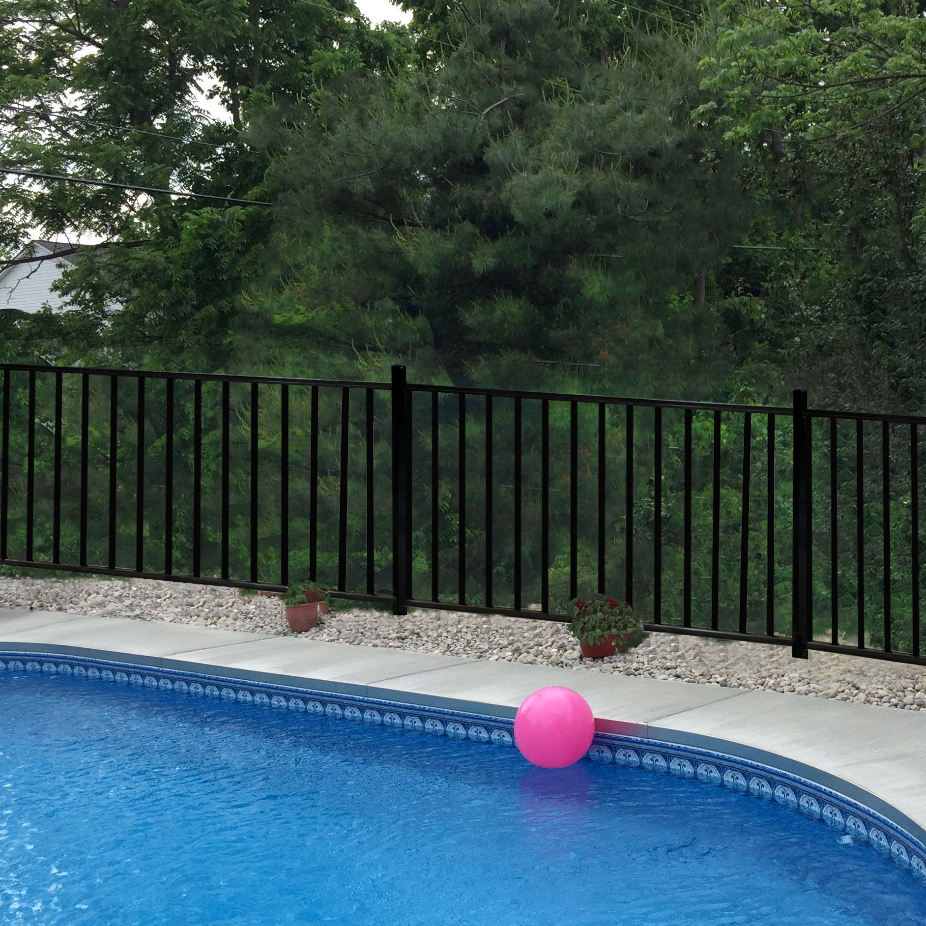 Pool with a pink ball and Weatherables Atlantic black aluminum fence in the background