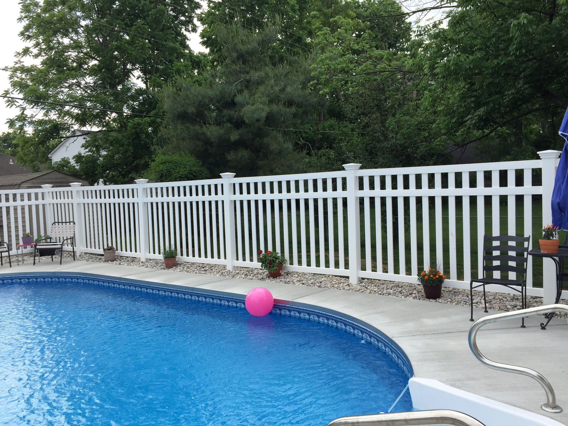 Pool with a pink ball, Weatherables Captiva white vinyl closed-top picket fence, and outdoor furniture
