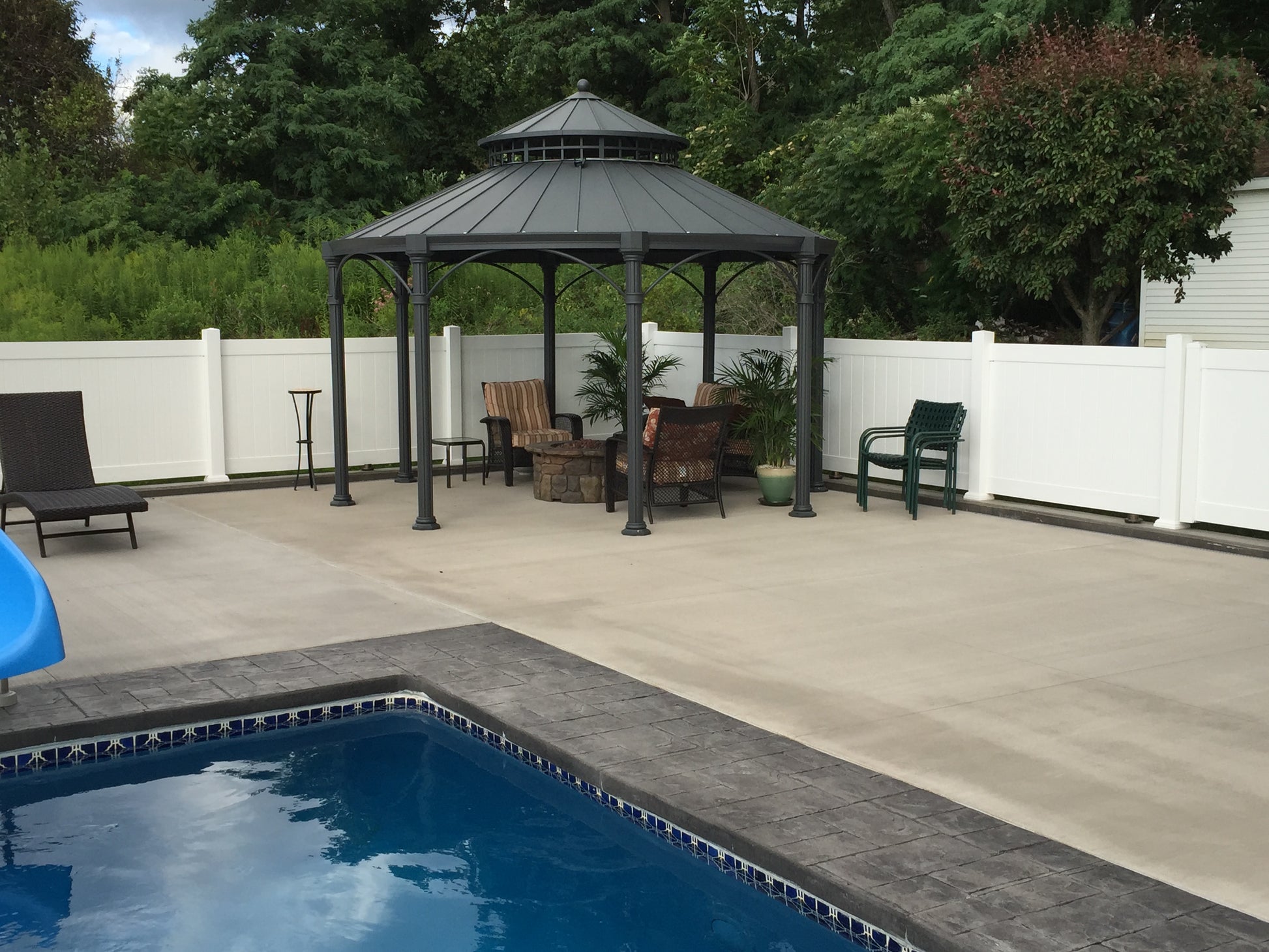 Gazebo with outdoor furniture near a poolside deck with Weatherables Pembroke white vinyl privacy fence