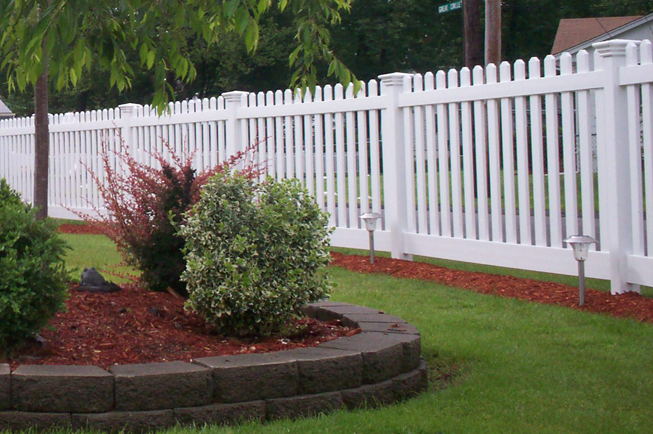 Lawn with garden bed, Weatherables Plymouth white vinyl picket fence, and trees