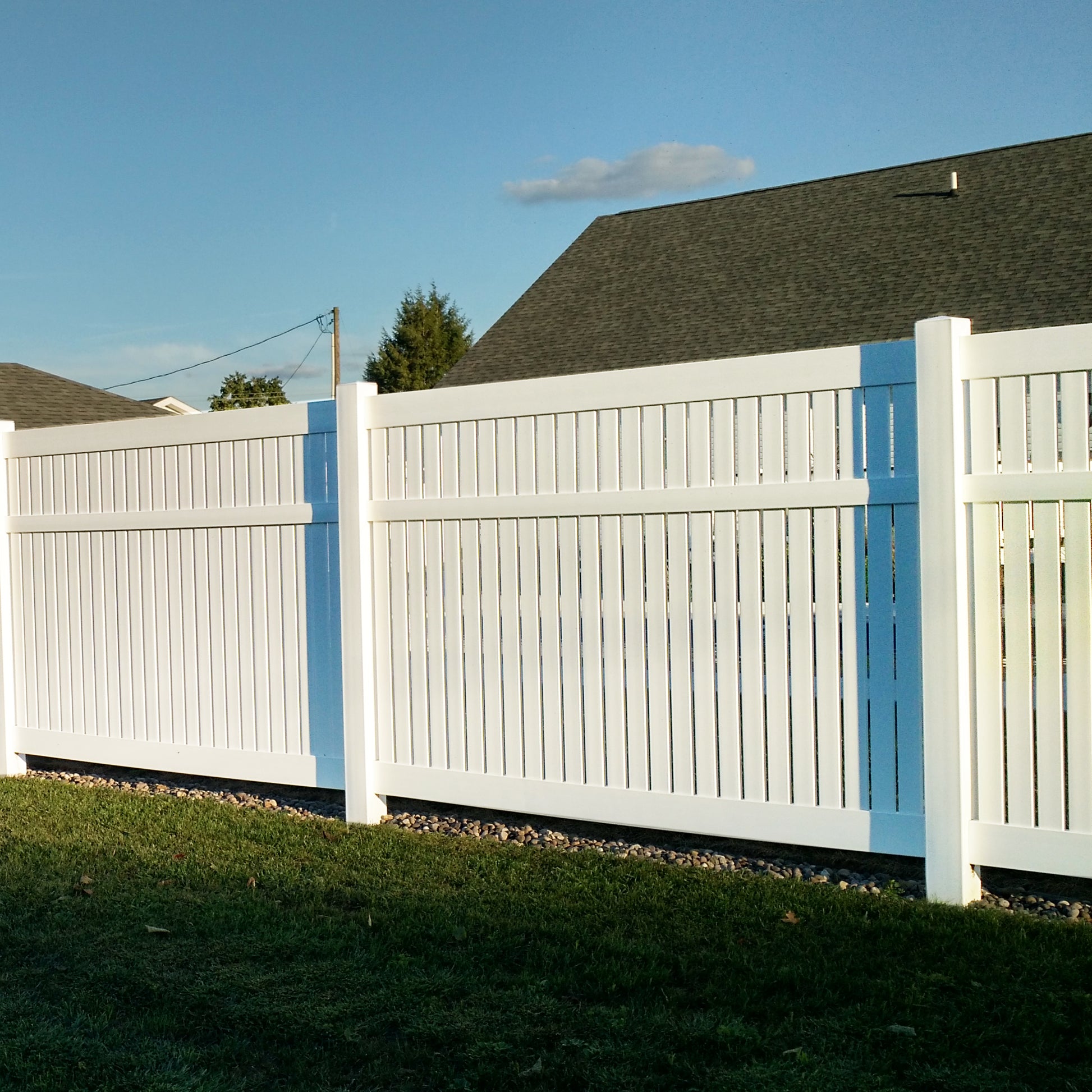 Weatherables Huntington white vinyl semi-privacy fence in a residential area