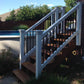 Wooden deck with white railing leading to a pool area