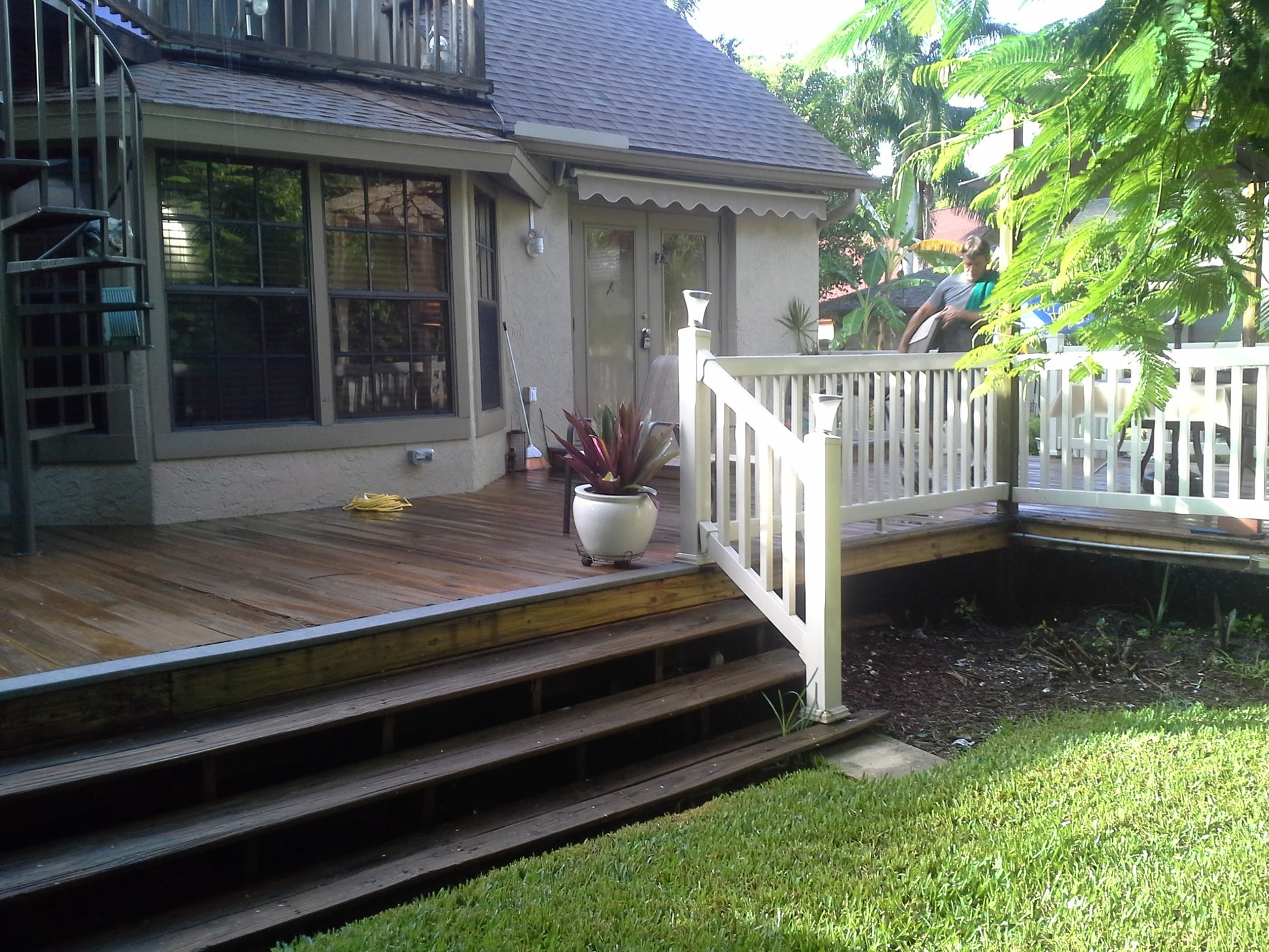 Backyard deck with steps leading to a house, featuring a potted plant, outdoor furniture and Weatherables Berkshire tan vinyl deck railing