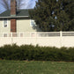 House with a Weatherables Scottdale tan vinyl privacy fence and greenery in front