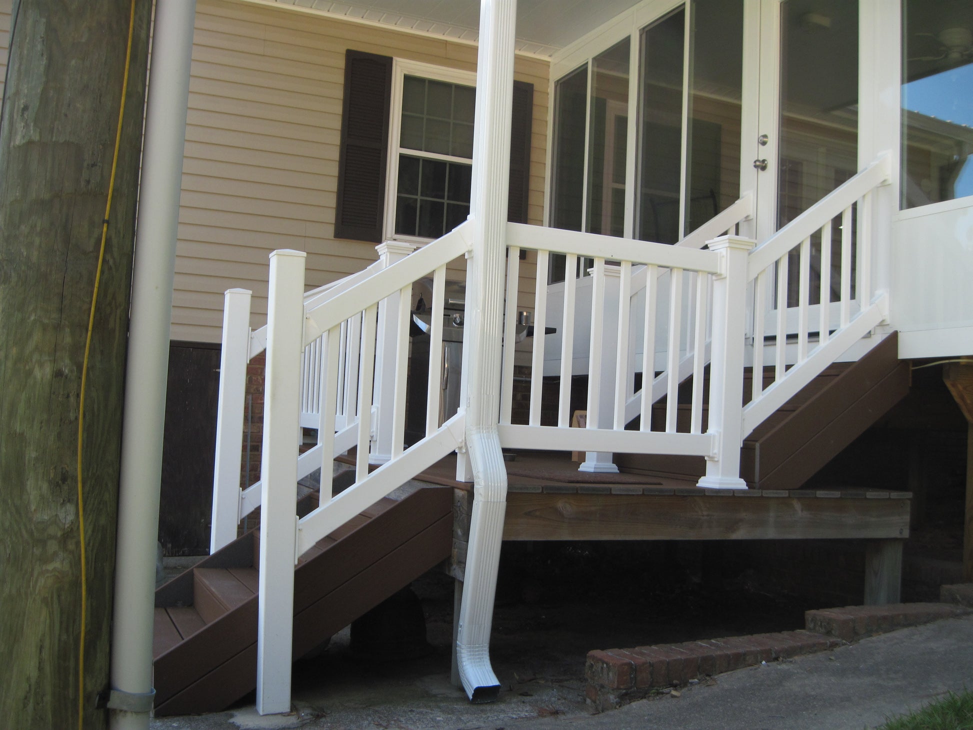 Weatherables Greenwich white vinyl stair railing on a set of stairs leading to a house porch.