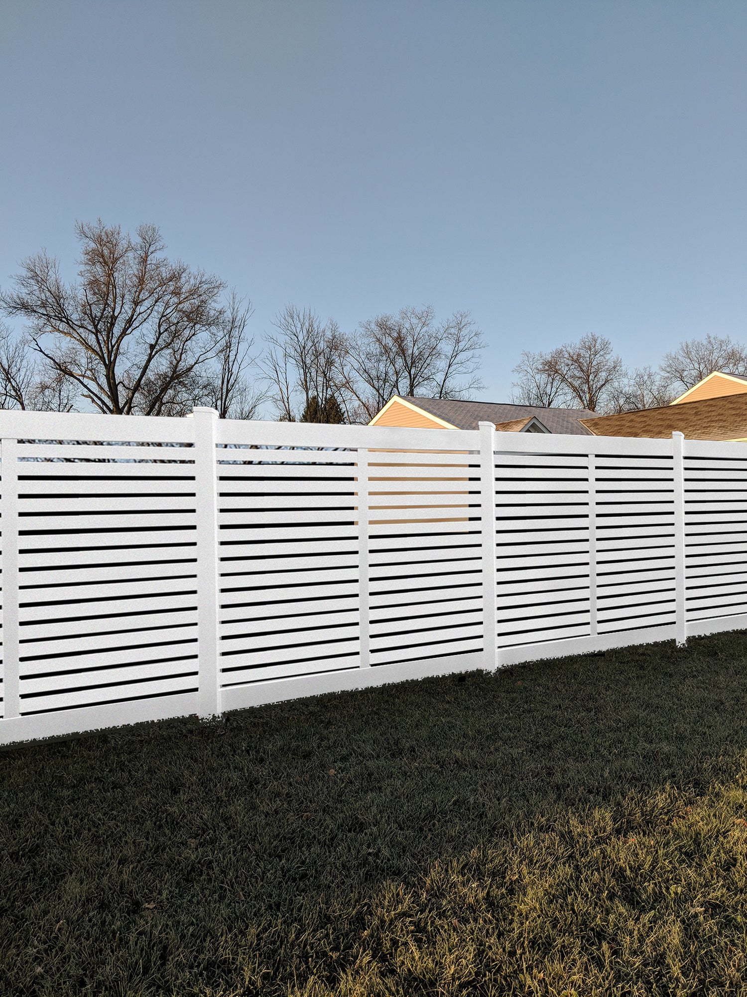 Weatherables Everglade white vinyl semi-privacy fence with horizontal slats in a residential area.