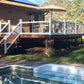 Backyard with pool, deck, Weatherables Wiltshire white vinyl deck railing and umbrella on a sunny day