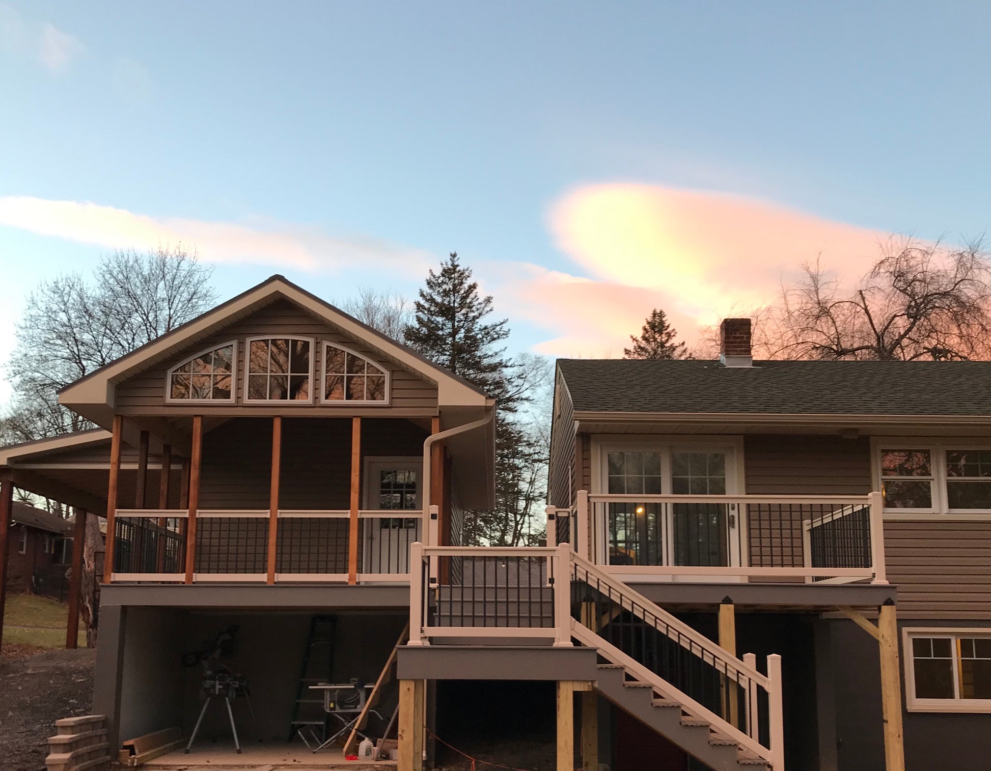 Two houses with Weatherables Wiltshire tan vinyl deck railings and balconies on a clear day.