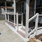 Porch with Weatherables Birmingham white vinyl deck railings and steps leading to a house entrance.