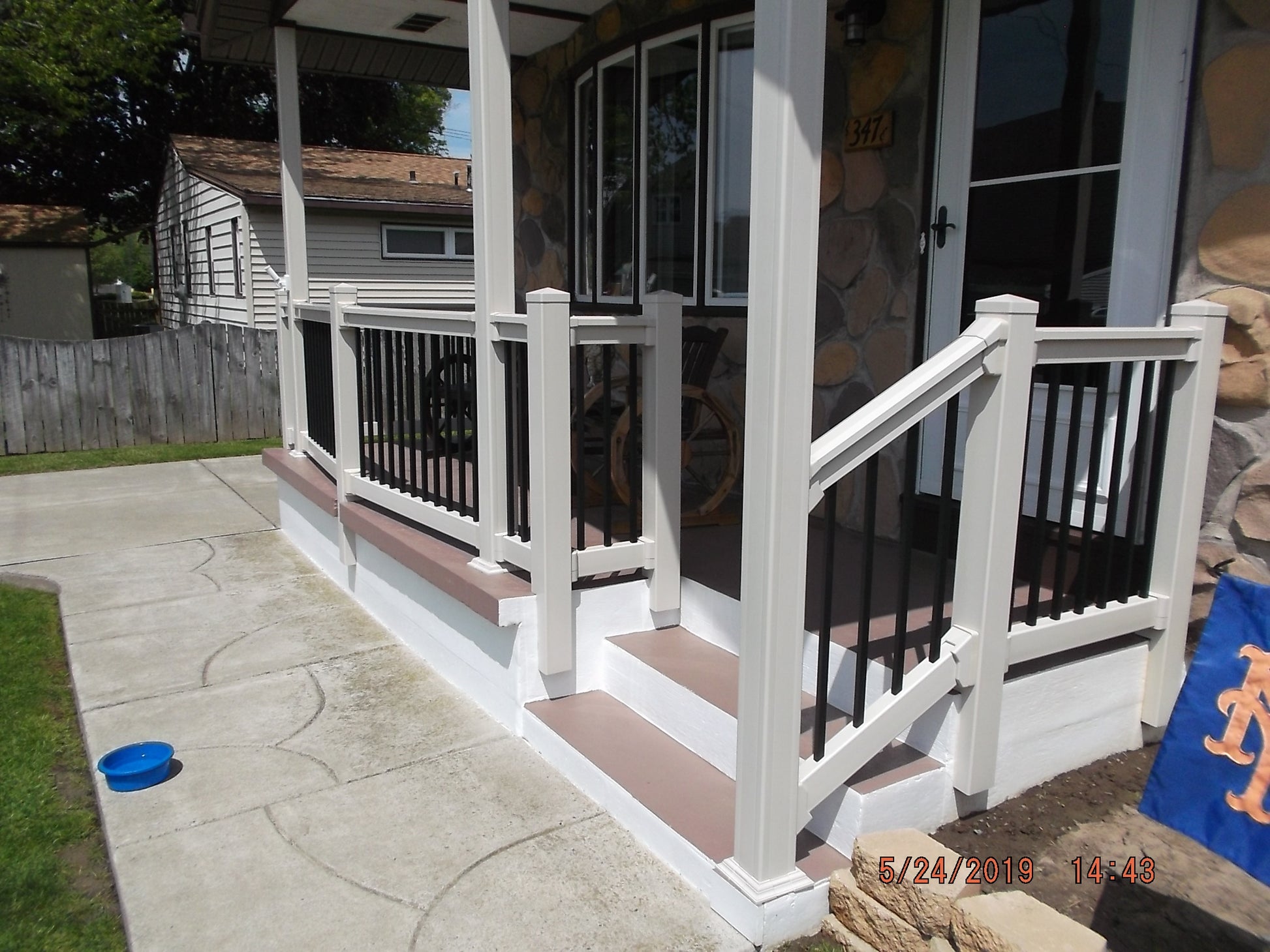 Porch with Weatherables Birmingham white vinyl deck railings and steps leading to a house entrance.