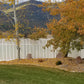 Backyard with trees, rocks, and a Weatherables Alden white vinyl semi-privacy fence in the background