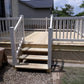 Wooden deck with Weatherables Greenwich white vinyl deck railings and steps leading to a house.