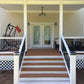 Front porch of a house with Weatherables Wiltshire white vinyl deck railing on wooden steps leading to the door