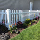 Weatherables Chelsea white vinyl picket fence with garden bed in front of a house