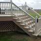 Weatherables Addison white vinyl stair railing on a  staircase leading to a deck with a grassy area and cloudy sky in the background