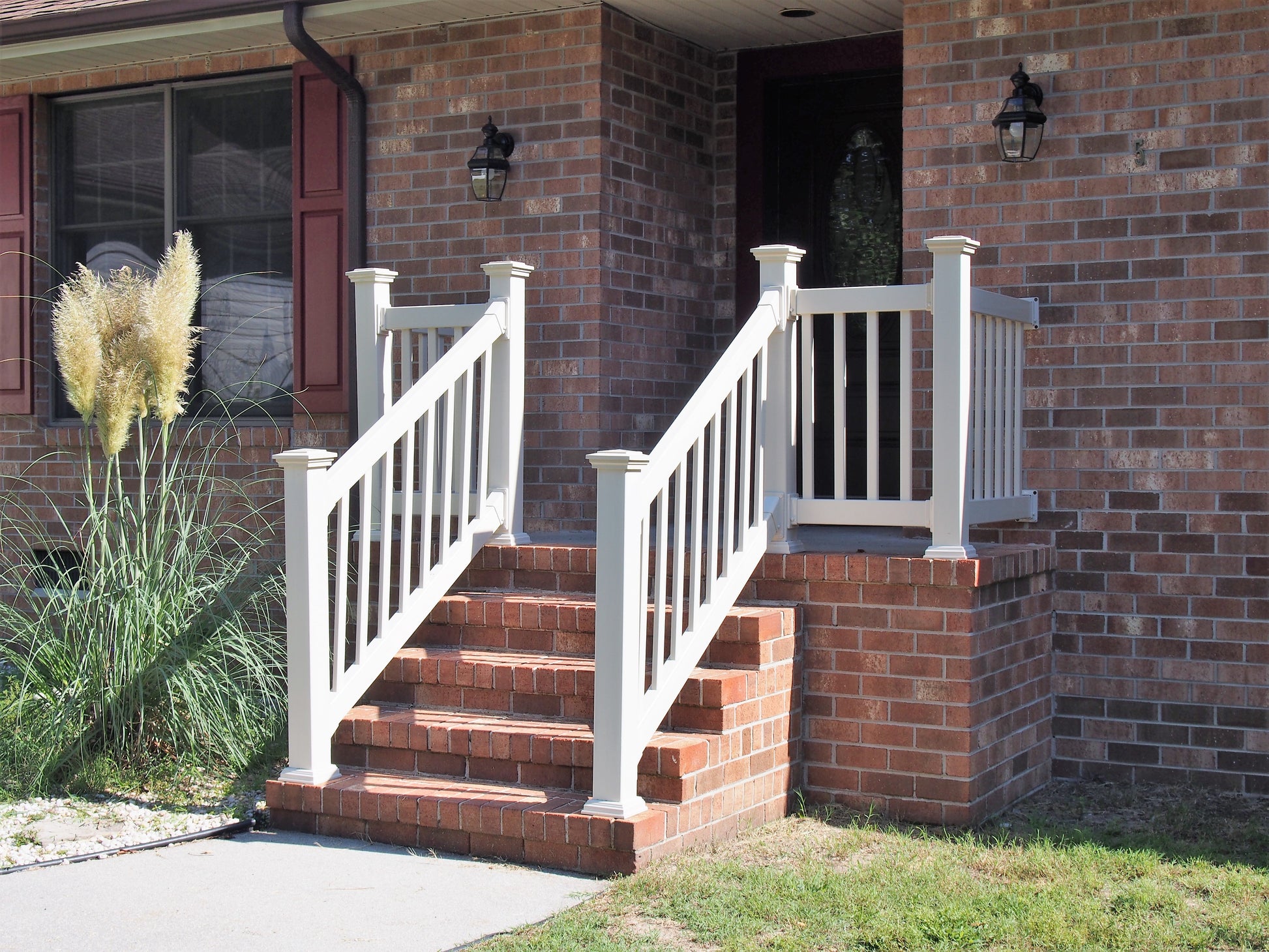 Weatherables Greenwich white vinyl railing on a brick staircase leading to a house entrance