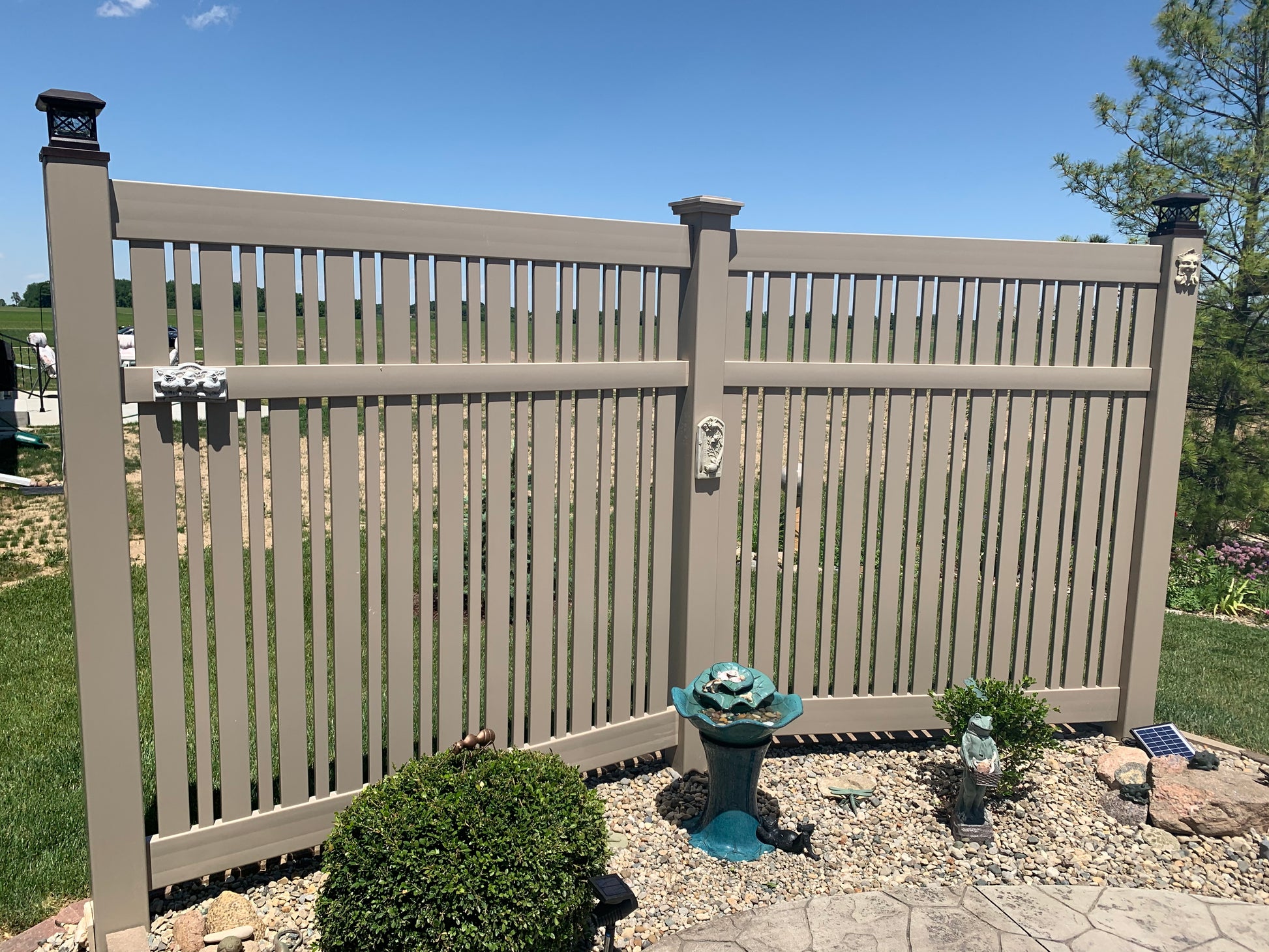 Weatherables Davenport khaki vinyl semi-privacy fence with decorative elements in a garden setting