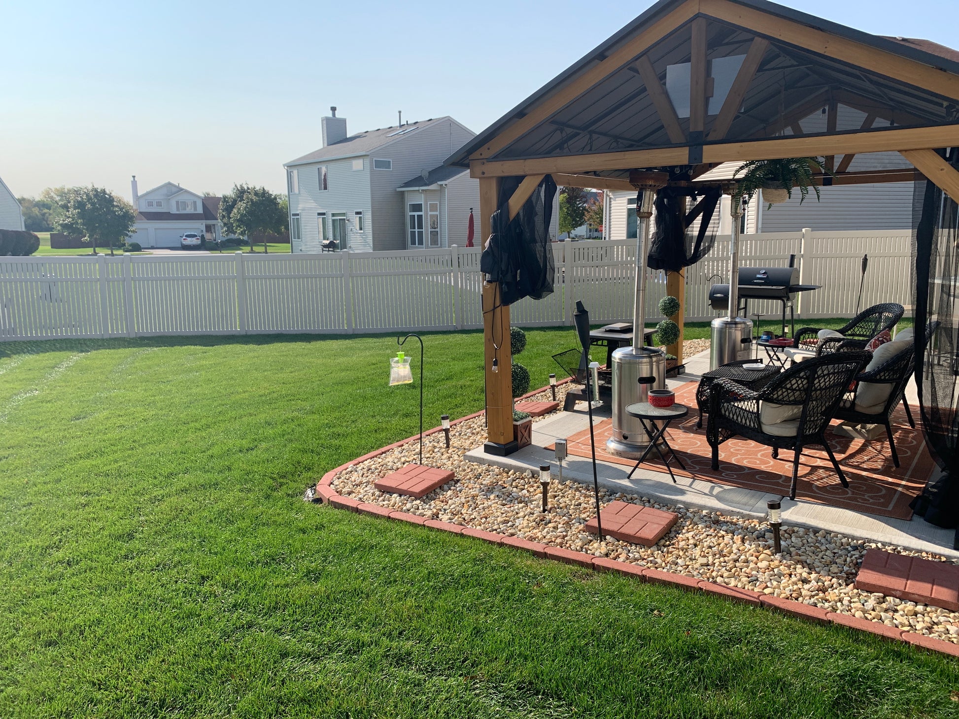Backyard with a patio area featuring a gazebo, outdoor furniture, Weatherables Huntington Tan vinyl semi-privacy fence and grill