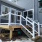 Newly constructed deck with Weatherables Wiltshire white vinyl stair railings on a residential house.
