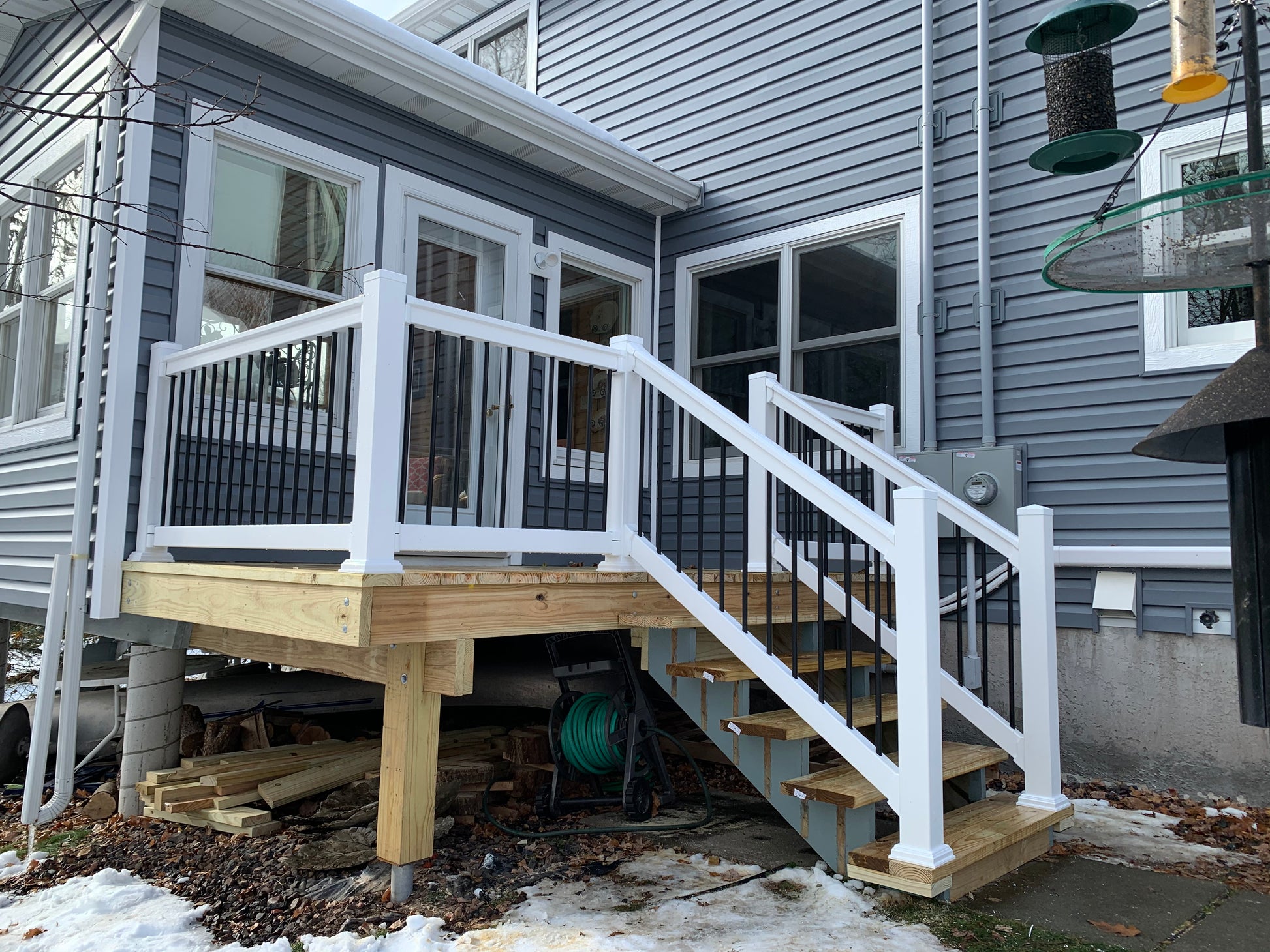 Newly constructed deck with Weatherables Wiltshire white vinyl stair railings on a residential house.