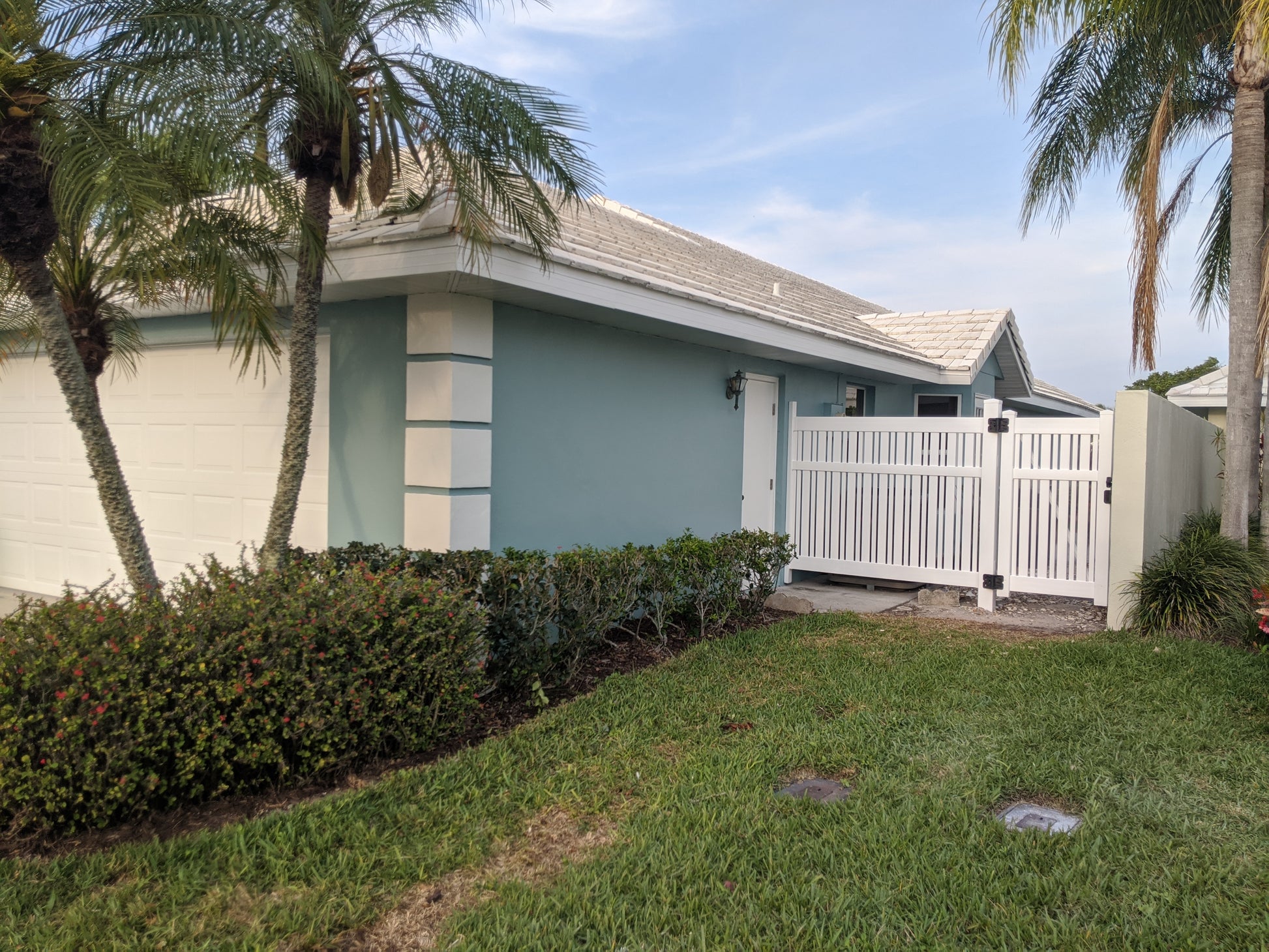 House with a Weatherables Alden white vinyl semi-privacy fence and palm trees in the front