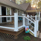 Backyard deck with Weatherables Derby white vinyl deck railing, dog on deck, and garden flag.