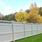 Weatherables Ashton white vinyl  privacy fence with lattice top in a backyard setting with trees and grass.