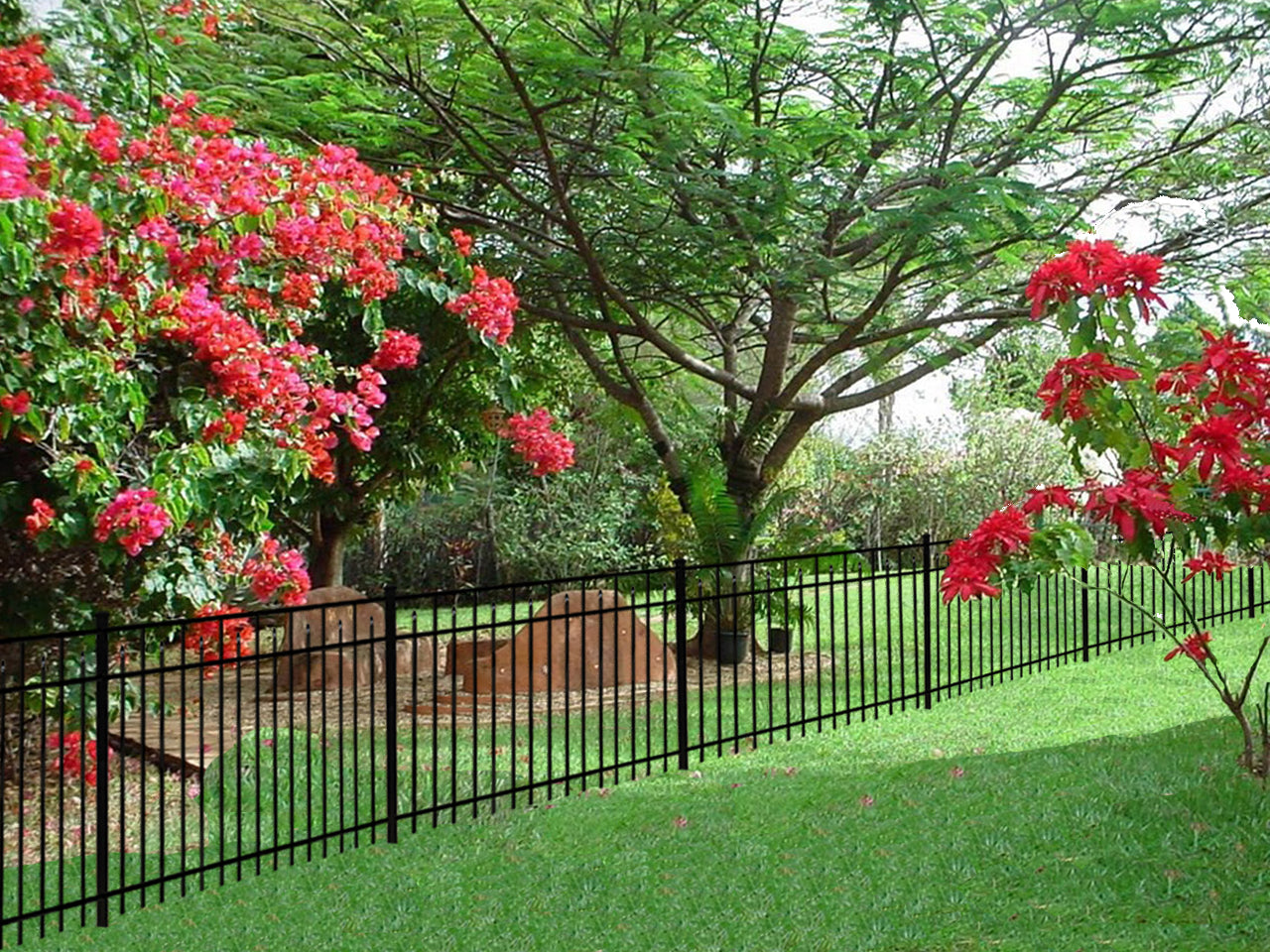 Garden with red flowers, Weatherables Toledo black metal fence, and large tree