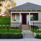 House with a red door and Weatherables Pacific black aluminum fence in a suburban setting