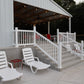 White lounge chairs on a patio with a covered outdoor area in the background.