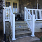 Weatherables Yorkshire white vinyl porch railing on a set of outdoor steps leading to a house entrance.