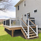 Wooden deck with Weatherables Lancaster white vinyl deckboard railings and stairs leading to a house.