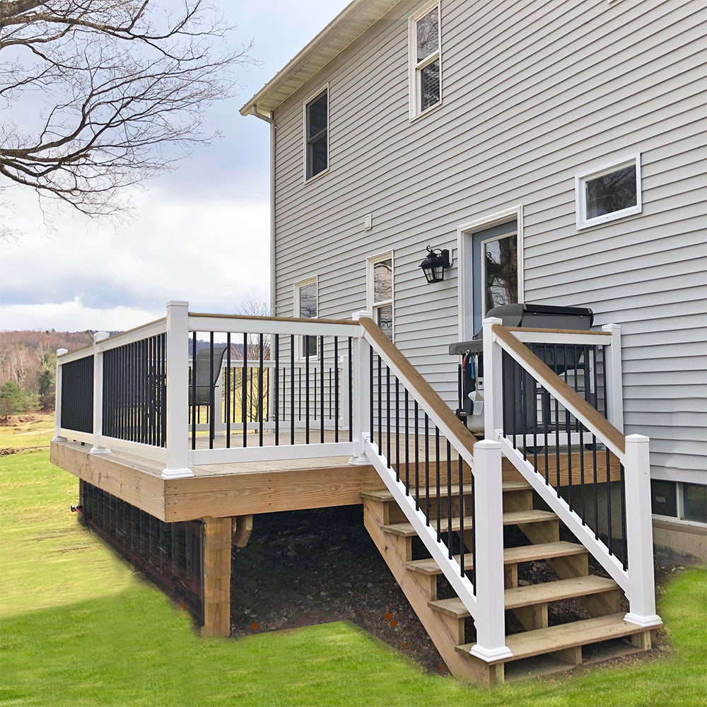 Wooden deck with Weatherables Lancaster white vinyl deckboard railings and stairs leading to a house.