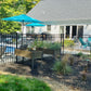 Backyard with pool, Weatherables Pacific black aluminum fencing, patio furniture, and a house in the background