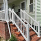 Brick staircase with Weatherables Greenwich white vinyl deck railing leading to a house entrance