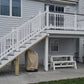 Weatherables Wakefield white vinyl deckboard stair raiiling on a staircase leading to a deck on a gray house
