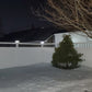 Snowy backyard with a tree and Weatherables Bradford white vinyl privacy fence at night