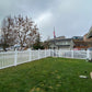 Backyard with Weatherables Chelsea white vinyl picket fence, grass, and a cloudy sky.