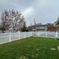 Backyard with Weatherables Chelsea white vinyl picket fence, grass, and a cloudy sky