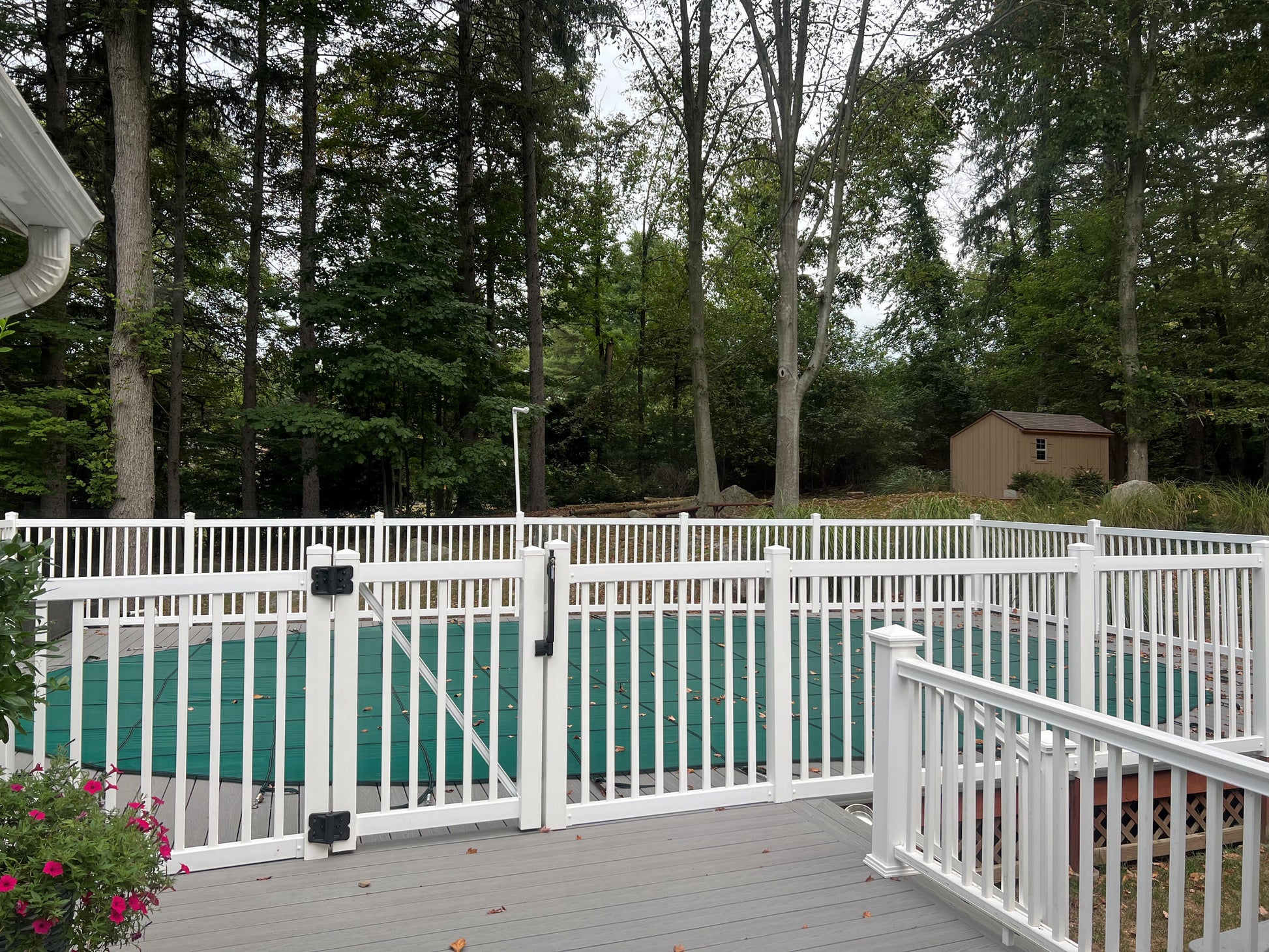 Weatherables Neptune white vinyl pool fence surrounding a pool area with trees in the background