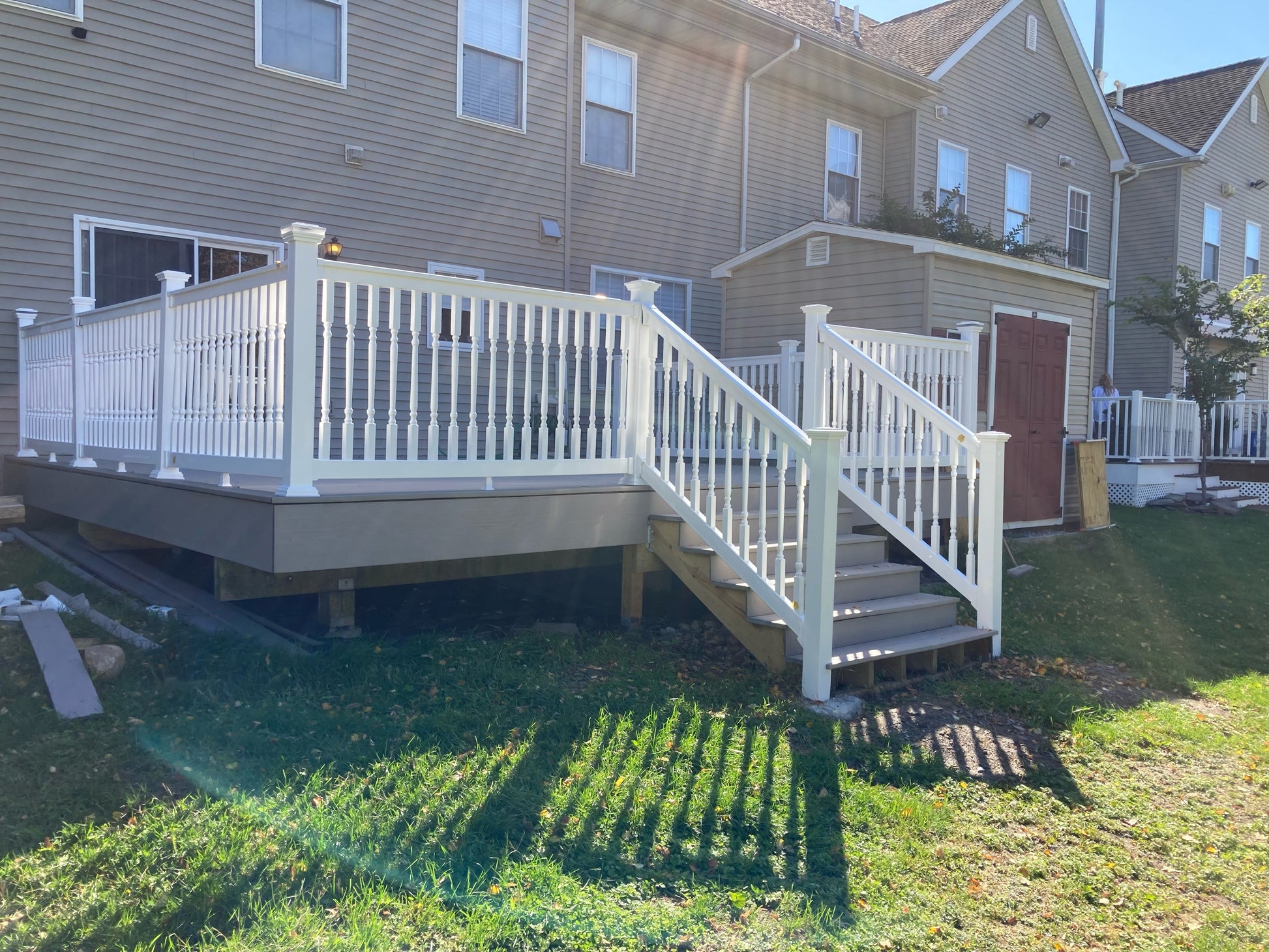 Weatherables Addison white vinyl deck railing on a deck with stairs leading to a house