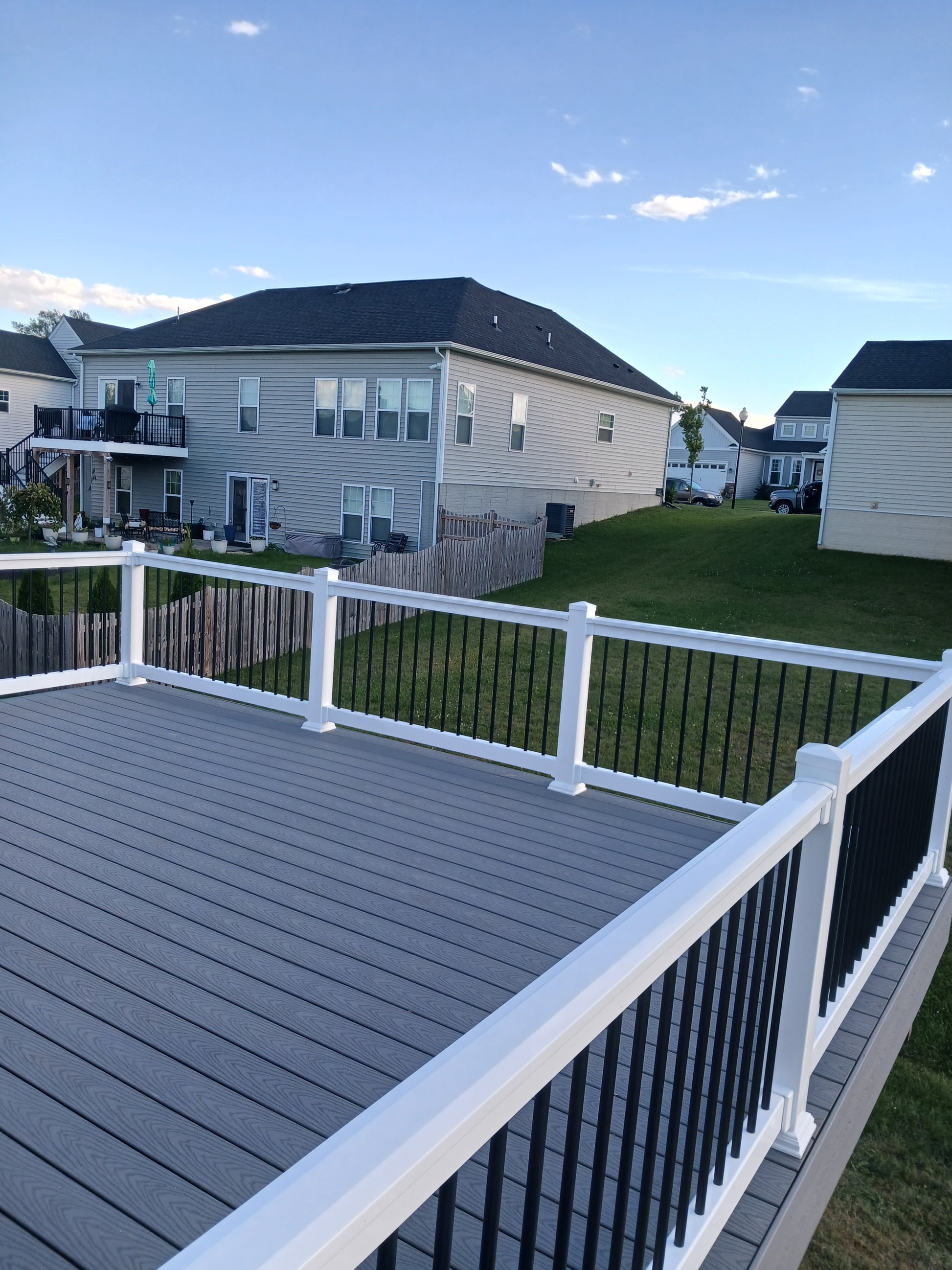 View from a high vantage point of a residential area with Weatherables Bolton white vinyl deck railing, houses and greenery.